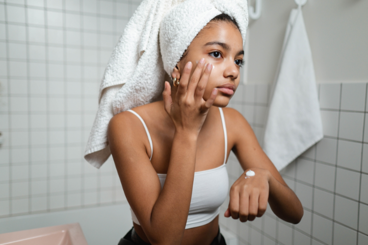 Model applying skincare to her face