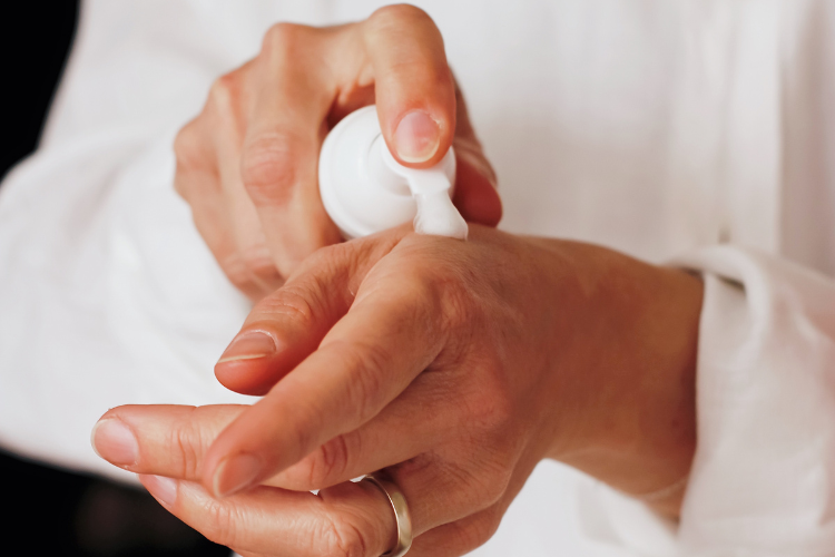 Model pouring skincare onto their hand